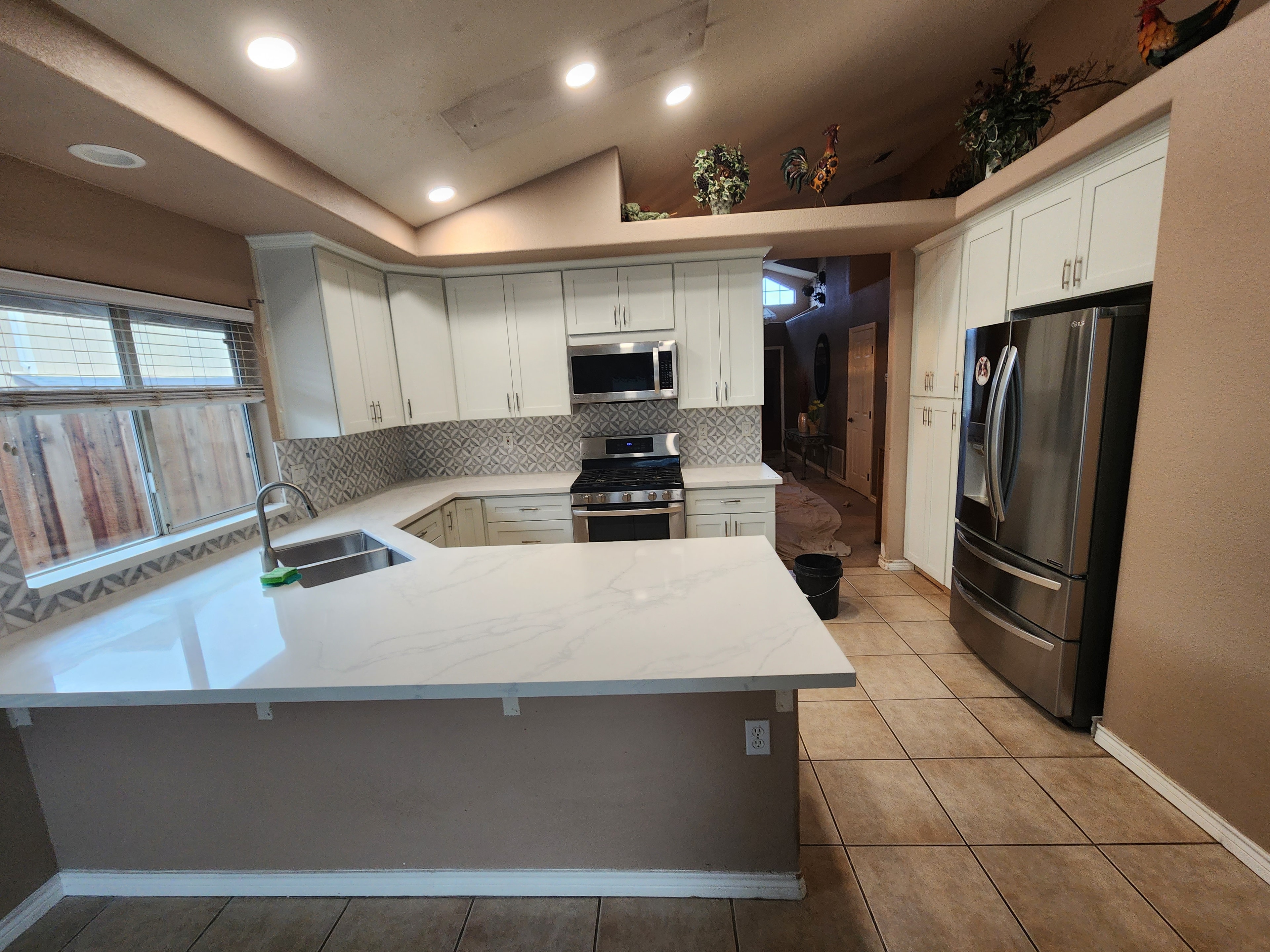 Kitchen remodel with white cabinets, quartz countertops and patterned backsplash
